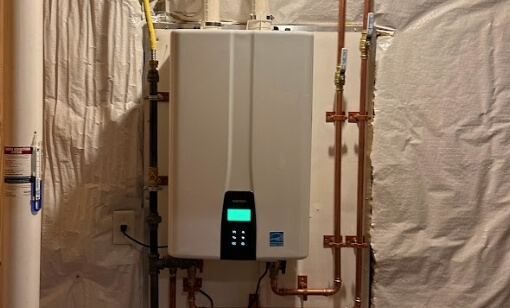 A wall mounted water heater in a basement.