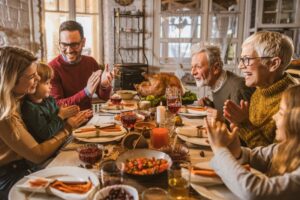 multigenerational-family-gathered-around-the-dinner-table-for-thanksgiving
